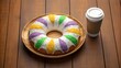 © NoorArt Studio - King cake with coffee on wooden table for mardi gras