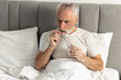 © brizmaker - Senior man takes medication in bed for health management and recovery