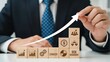 © Smartra - Businessman s hand guides upward arrow over wooden blocks with business icons symbolizing growth
