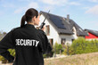 © New Africa - Security guard using radio near house outdoors. Private property protection