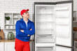 © Pixel-Shot - Happy male worker of repair service near fridge in kitchen