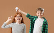 © Pixel-Shot - Cute inventors pointing at light bulb on beige background
