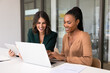 © fizkes - Two happy multiethnic business partners working on Internet project together