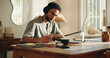 © peopleimages.com - Man, journalist and writing with laptop in home for online story, article or remote work. Male person, freelancer or taking notes with book, headphones or computer for journalism or schedule diary