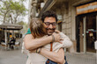 © Drobot Dean - A woman smiles with her eyes closed while hugging a woman while they stand