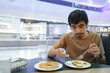 © Chocheng channel - Young asian man eating salad in restaurant