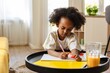 © Drobot Dean - Daughter draws in a sketchbook with a pen and sits at a table