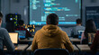 © Kasper - Rear view of focused students sitting at desks in a modern computer lab working on laptops while learning programming with code displayed on a projection screen.