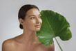 © Buyanskyy Production - Woman with Clear Skin Holding Green Leaf