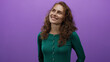© Krakenimages.com - Woman smiling joyfully against a vibrant purple background wearing a green sweater, showcasing happiness and positive emotion.