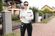 © New Africa - Security guard in uniform near house outdoors. Private property protection