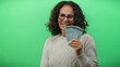 © Krakenimages.com - Middle-aged woman holding malaysian ringgit banknotes against a green wall background, smiling and showcasing financial success.
