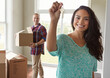 © peopleimages.com - Happy couple, portrait or moving in with keys or boxes for property investment or new home together. Female person, homeowner or tenant with smile, packages or access for rent or mortgage in house