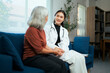 © Parichat - Doctor visiting senior patient providing healthcare consultation at home
