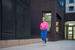 © Jelena - Mature woman jogging outdoors wearing headphones