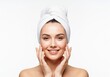 © Meow Creations - Happy young woman with a white towel turban touching her face demonstrating healthy fresh skin.