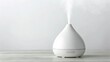 © supaporn - 3D Household Appliances A minimalist diffuser emitting steam on a light surface, promoting relaxation and wellness.