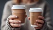 © AnnovaGraphics - Woman holding two takeaway coffee cups, perfect for a cozy morning or afternoon