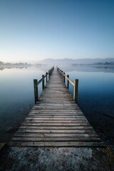  Serene lakeside scene: straight pier and mirrored sky in calm water