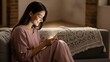 © Tanakorn - Smiling young woman relaxing on a cozy sofa, illuminated by her glowing mobile phone screen, enjoying digital content in a tranquil evening setting