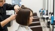 © Tanakorn - Young woman receives trendy bob haircut from professional hairdresser in bright beauty salon for a stylish transformation