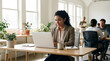 © abu - Focused young businesswoman working confidently in a bright modern office.