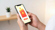 © Lilith_Saly - Person holds a smartphone displaying a digital red envelope payment interface with coins and a send button, symbolizing mobile transfers and wallet transactions.
