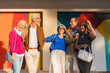 © pablo - Group of happy senior friends smiling standing outdoors in front of a colorful wall