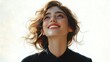 © Mariya - Portrait of a young woman with curly hair looking upwards and smiling with a joyful and hopeful expression