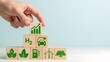 © Nabil - Strategic growth in clean energy technologies leading to a sustainable future and environmental prosperity, represented by a hand stacking eco-friendly icon blocks