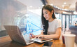 © dodotone - Young adult woman using cloud storage data connection system technology workflow using laptop working in cafe