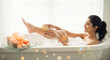 © Shivani - Young Woman Enjoys Relaxing Bubble Bath with Lit Candles