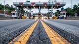 Approaching a busy toll plaza on a highway with yellow lane markings and overhead structures in overcast weather