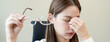 © Pormezz - Eye problem concept, fatigue asian young woman tired eyes, irritated rubbing eye dry relief vision pain after work on laptop computer, eye strain, hand holding glasses, suffer migraine, bad blurry