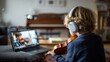 © phy - A young boy wearing headphones, playing the violin in front of a laptop screen, with a wooden floor and a bookshelf in the background.