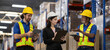 © eakgrungenerd - Warehouse workers and female supervisor using digital tablets and clipboard to discuss inventory management. Team collaboration concept in modern logistics and supply chain operations.