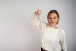 © Nenad - Unhappy businesswoman showing thumbs down gesture looking at camera isolated