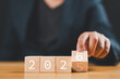 © Nirusmee - Businessman flipping wooden blocks from 2025 to 2026, symbolizing the New Year, future planning, business goals, and a fresh start.
