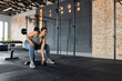 © Wavebreak Media - Asian woman bending forward on bench grabbing dumbbell beside rack in fitness studio, copy space