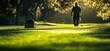 © kids - A lone golfer walks the green fairway at sunset.