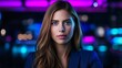 © Raul - Attractive woman stares forward while posing in front of a blurry city backdrop with purple and blue lights.