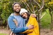 © Wavebreak Media - Diverse couple hugging and smiling while standing in fruit tree orchard wearing beanies and scarf