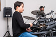 © Alan - Young drum student focused on the teacher’s movements while they play together at the drum kit. Private lesson centered on rhythm practice, percussion technique, and musical development