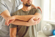 © Studio Romantic - Cropped photo of a male professional chiropractor or physical therapist working with Caucasian man's arm in rehabilitation hospital. Physiotherapy and osteopathic medicine concept.
