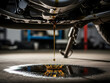 © Asif - car engine detail, Motor oil drips from car engine onto concrete floor. Dark liquid forms puddle, indicating repair or maintenance need. Automotive mechanical issue shown close up.