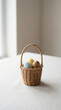 © Taya - Easter eggs in wicker basket on table, pastel colored eggs, spring holiday decoration, minimal natural light still life, Easter composition for celebration, seasonal festive decor photograph