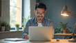 © Vadym - Man smiles using laptop computer for online learning or work. He studies digital courses with e-learning webinar at home office. Modern man develops skills via internet connection.