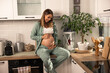 © milanmarkovic78 - Pregnant Woman Sitting On Kitchen Counter In The Morning