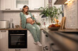 © milanmarkovic78 - Pregnant Woman Sitting On Kitchen Counter In The Morning