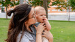 © ADDICTIVE STOCK - Mother lovingly holding baby in park setting